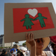 A woman holds a cardboard sign as thousands of Catholics and conservatives gather against the legalization of gay marriage.